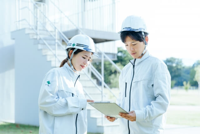 工事現場で図面を確認する技術者たち