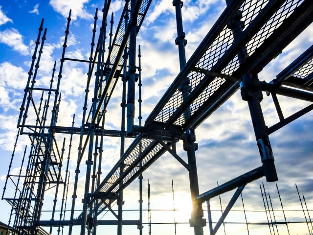 青空と鉄骨構造の大規模建設現場